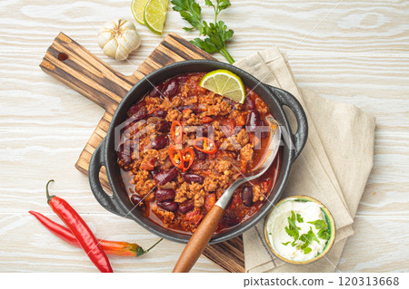 Mexican dish chili con carne with minced meat, red beans, lime, and spices top view 120313668