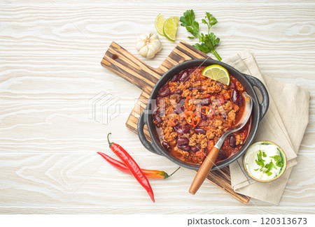 Mexican dish chili con carne with minced meat, red beans, lime, and spices top view, space for text 120313673
