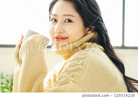 Young woman in winter clothes drinking coffee 120314220