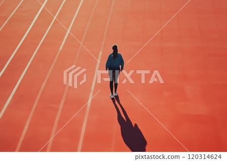 Female athlete preparing to run on a red track 120314624