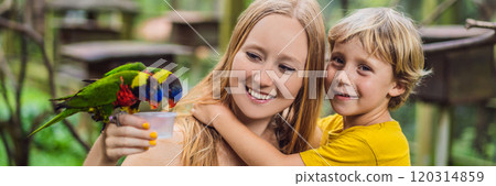 Mom and son feed the parrot in the park. Spending time with kids concept BANNER, LONG FORMAT 120314859