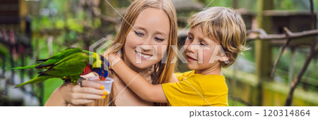 Mom and son feed the parrot in the park. Spending time with kids concept BANNER, LONG FORMAT 120314864