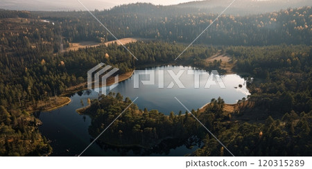 A lake surrounded by trees with a clear blue sky in the background A lake surrounded by trees with a clear blue sky in the background 120315289