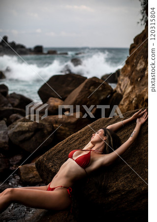 Experience Serene Beachside Relaxation in a Vibrant Red Bikini by the Oceans Embrace Experience Serene Beachside Relaxation in a Vibrant Red Bikini by the Oceans Embrace 120315804