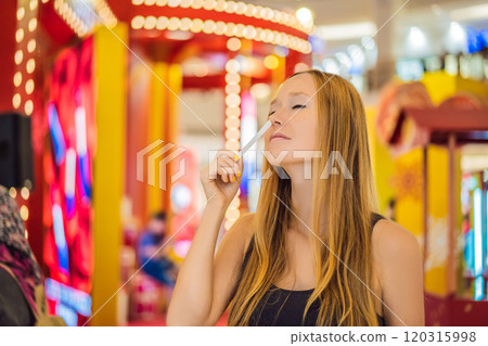 A woman with paper strips in her hands listens to the fragrance in the mall 120315998