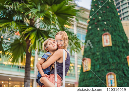 Mom and son on the background of Christmas Tree and Palm Trees Decorated in tropical holiday location 120316039