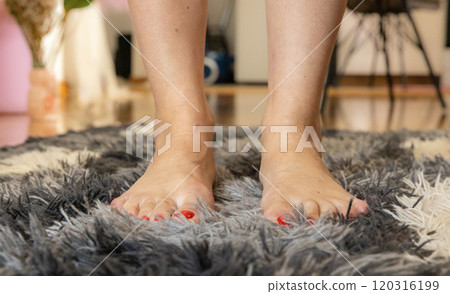 Barefoot woman on white gray carpet at home, closeup 120316199