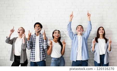 Education concept. Teens pointing up on free space over white brick wall Education concept. Teens pointing up on free space over white brick wall 120316270