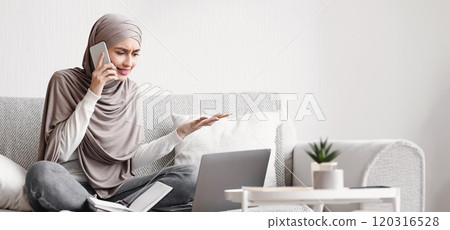 Remote Work Disadvantages Concept. Furious muslim woman arguing on cellphone while working on laptop at home as freelancer, empty space 120316528