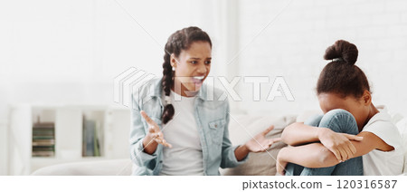 Elder african american sister shouting at younger sister, fighting at home, little girl crying, empty space Elder african american sister shouting at younger sister, fighting at home, little girl crying, empty space 120316587