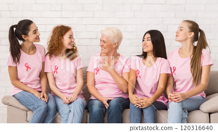 Breast Cancer Survivors. Diverse Women In Pink T-Shirts Sharing Treatment Experience Sitting On Sofa Indoor. 120316640