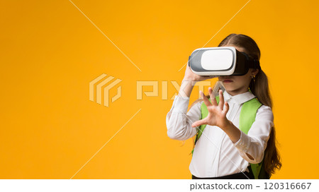 Innovative Education. Schoolgirl Wearing VR Glasses Experiencing Virtual Reality In Studio Over Yellow Background. Copy Space 120316667