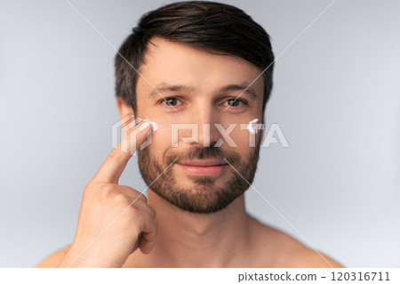 Skincare. Middle Aged Man Applying Anti-Aging Cream On Face Skin Over White Background. Studio Shot, Isolated Skincare. Middle Aged Man Applying Anti-Aging Cream On Face Skin Over White Background. Studio Shot, Isolated 120316711