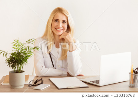Female Doctor In White Coat Looking At Camera In Office 120316768