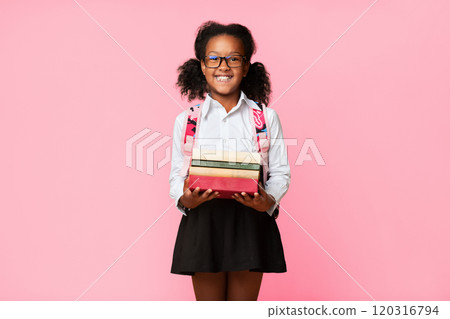 Quarantine Reading Homework. Happy Black Schoolgirl Holding Books Smiling To Camera Posing In Studio On Yellow Background. Quarantine Reading Homework. Happy Black Schoolgirl Holding Books Smiling To Camera Posing In Studio On Yellow Background. 120316794