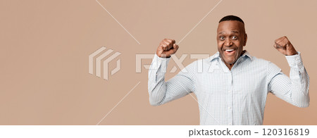 Strong middle aged african american man showing biceps at camera, orange panorama background 120316819