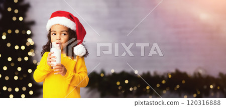 Christmas Eve drink for kids. Cute little african american girl enjoying warm milk at home, empty space 120316888