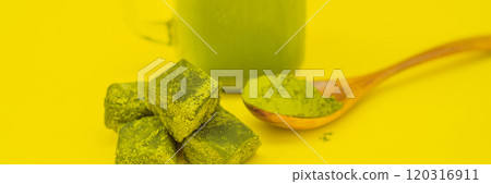 Green tea latte with ice in mason jar and straw and spoon with powder matcha and candy made of matcha on yellow background. Homemade Iced Matcha Latte Tea with Milk zero waste BANNER, LONG FORMAT Green tea latte with ice in mason jar and straw and spoon with powder matcha and candy made of matcha on yellow background. Homemade Iced Matcha Latte Tea with Milk zero waste BANNER, LONG FORMAT 120316911