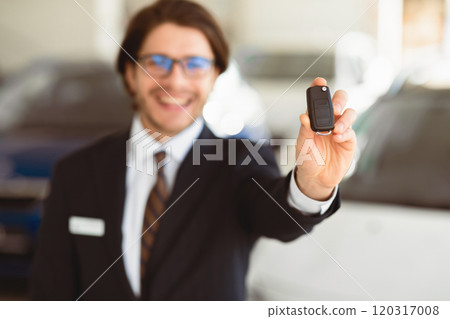 Car Rent. Unrecognizalble Agent Showing Auto Key Standing In Automobile Rental Office. Copyspace, Shallow Depth 120317008