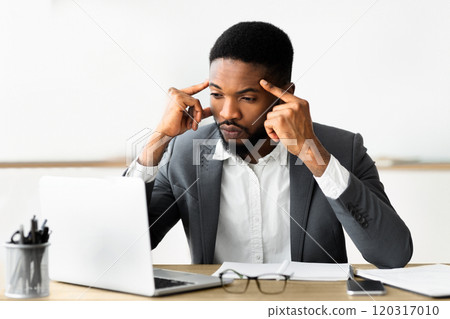 Concentrated african employee analyzing information on laptop, working in office, copy space Concentrated african employee analyzing information on laptop, working in office, copy space 120317010