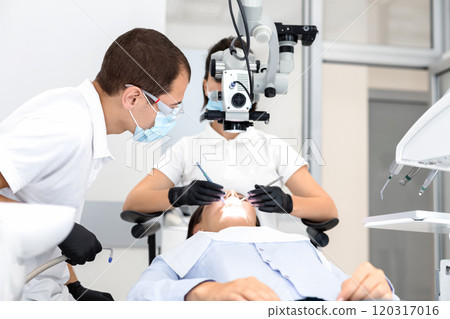 High class service in dental office, female dentist making surgery assisted by male doctor, free space 120317016