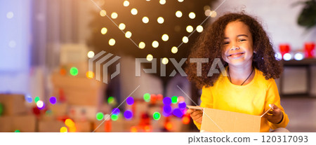 Cherished present. Cheerful afro girl enjoying her glowing Christmas present at home 120317093