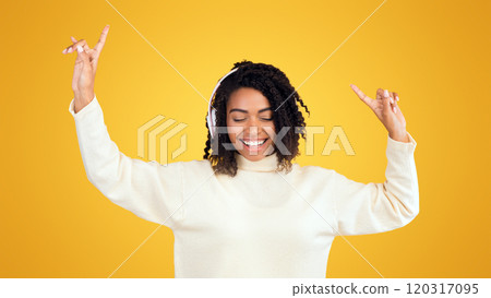 Favorite Music. Happy african american woman listening to music with headphones and dancing 120317095