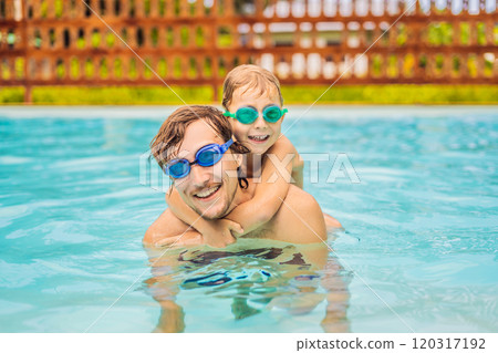 Dad and son in swimming Goggles have fun in the pool 120317192