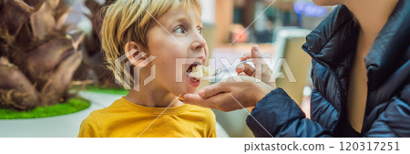 Boy at the airport - Young boy eating food while waiting for his flight BANNER, LONG FORMAT 120317251