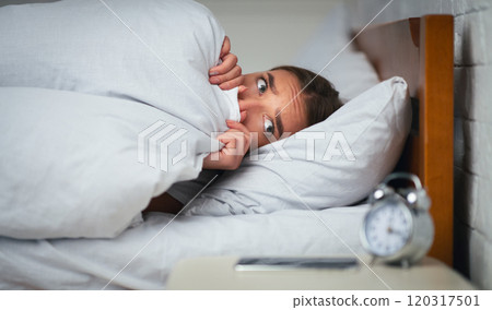 Anxiety And Sleeplessness. Scared Woman Lying In Bed Pulling Blanket Over Face Looking At Clock At Home. Selecive Focus 120317501
