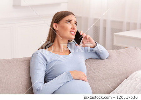 Pregnant Lady Talking On Phone Calling Doctor Feeling Bad Sitting On Sofa At Home. Empty Space 120317536
