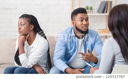 Afro Husband Sharing Family Problems Sitting Next To His Offended Wife At Counselor's Office, Selective Focus 120317767