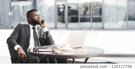 Thoughtful African American Businessman Sitting At Laptop Touching Chin In Outdoor Cafe. Strategic Thinking Concept. Free Space Thoughtful African American Businessman Sitting At Laptop Touching Chin In Outdoor Cafe. Strategic Thinking Concept. Free Space 120317789