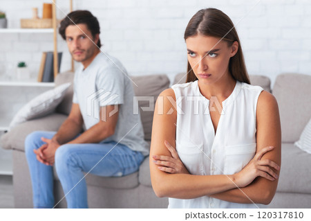 After Quarrel. Angry Woman Standing Crossing Hands Dissatisfied With Boyfriend's Behavior At Home 120317810
