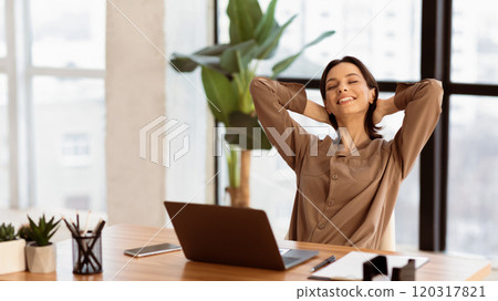 Good Morning. Happy businesswoman working at office and stretching her arms, front view, copyspace, panorama Good Morning. Happy businesswoman working at office and stretching her arms, front view, copyspace, panorama 120317821
