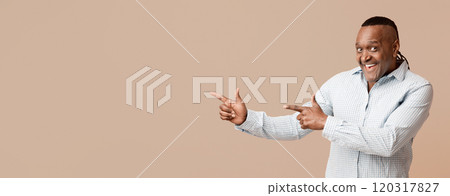 Check it out. Emotional mature afro american pointing at copy space, orange panorama background Check it out. Emotional mature afro american pointing at copy space, orange panorama background 120317827