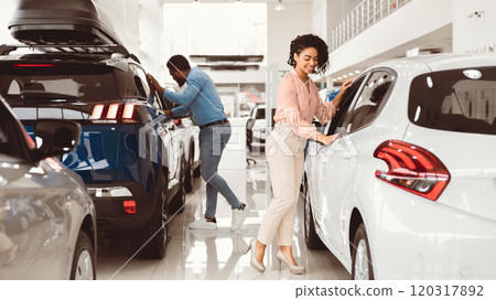 Couple Buying Car. African Spouses Choosing New Family Automobile In Luxury Dealership Store. Panorama Couple Buying Car. African Spouses Choosing New Family Automobile In Luxury Dealership Store. Panorama 120317892