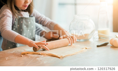 Father and daughter rolling dough together in kitchen to make cookies, using wooden rolling pin, cooking at home, enjoying homemade pastry, preparing pizza, love baking, cropped image with free space Father and daughter rolling dough together in kitchen to make cookies, using wooden rolling pin, cooking at home, enjoying homemade pastry, preparing pizza, love baking, cropped image with free space 120317926