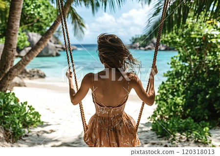 Tourist enjoying swinging on tropical beach in la digue, seychelles 120318013