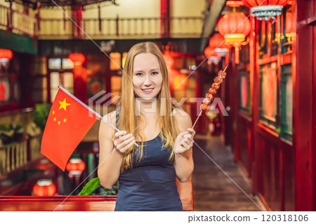 Enjoying vacation in China. Happy woman tourist with a Chinese flag and with traditional Chinese candied fruits on a Chinese background. Travel to China concept. Visa free transit 72 hours, 144 hours Enjoying vacation in China. Happy woman tourist with a Chinese flag and with traditional Chinese candied fruits on a Chinese background. Travel to China concept. Visa free transit 72 hours, 144 hours 120318106