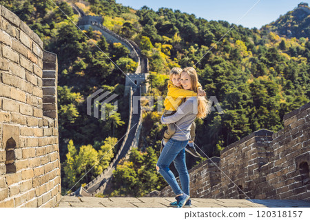 Happy cheerful joyful tourists mom and son at Great Wall of China having fun on travel smiling laughing and dancing during vacation trip in Asia. Chinese destination. Travel with children in China 120318157
