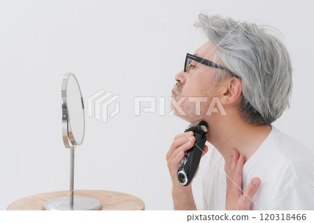 Middle-aged gray-haired man shaving his beard Middle-aged gray-haired man shaving his beard 120318466