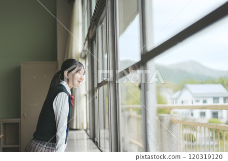 Japanese female junior high school student looking out the window of her school classroom Japanese female junior high school student looking out the window of her school classroom 120319120