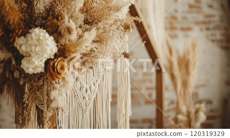 A stunning floral arrangement featuring dried flowers and greenery is showcased against a rustic backdrop with macrame details. 120319329
