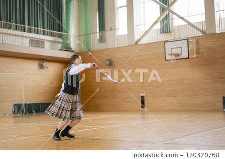 A girl playing badminton in the gym A girl playing badminton in the gym 120320768