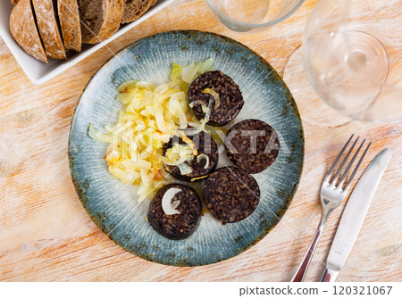 Morcilla con cebolla - fried blood sausage with onion on table Morcilla con cebolla - fried blood sausage with onion on table 120321067