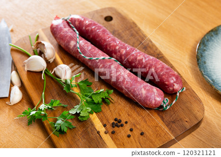 Sausages served with herbs to table 120321121