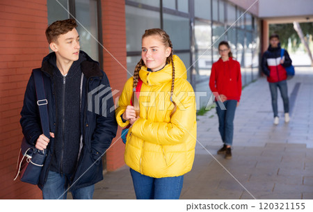 Teen girl with classmate walking to college Teen girl with classmate walking to college 120321155