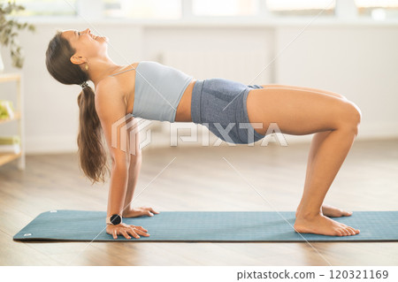 Sporty girl performing Reverse Table Top Pose in yoga studio Sporty girl performing Reverse Table Top Pose in yoga studio 120321169