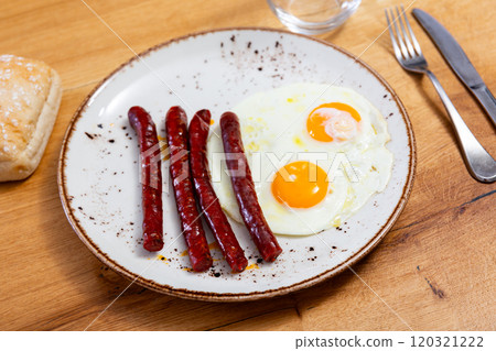 Fried eggs served with chistorra sausages 120321222